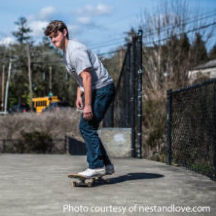 Teenager on skate board outdoors